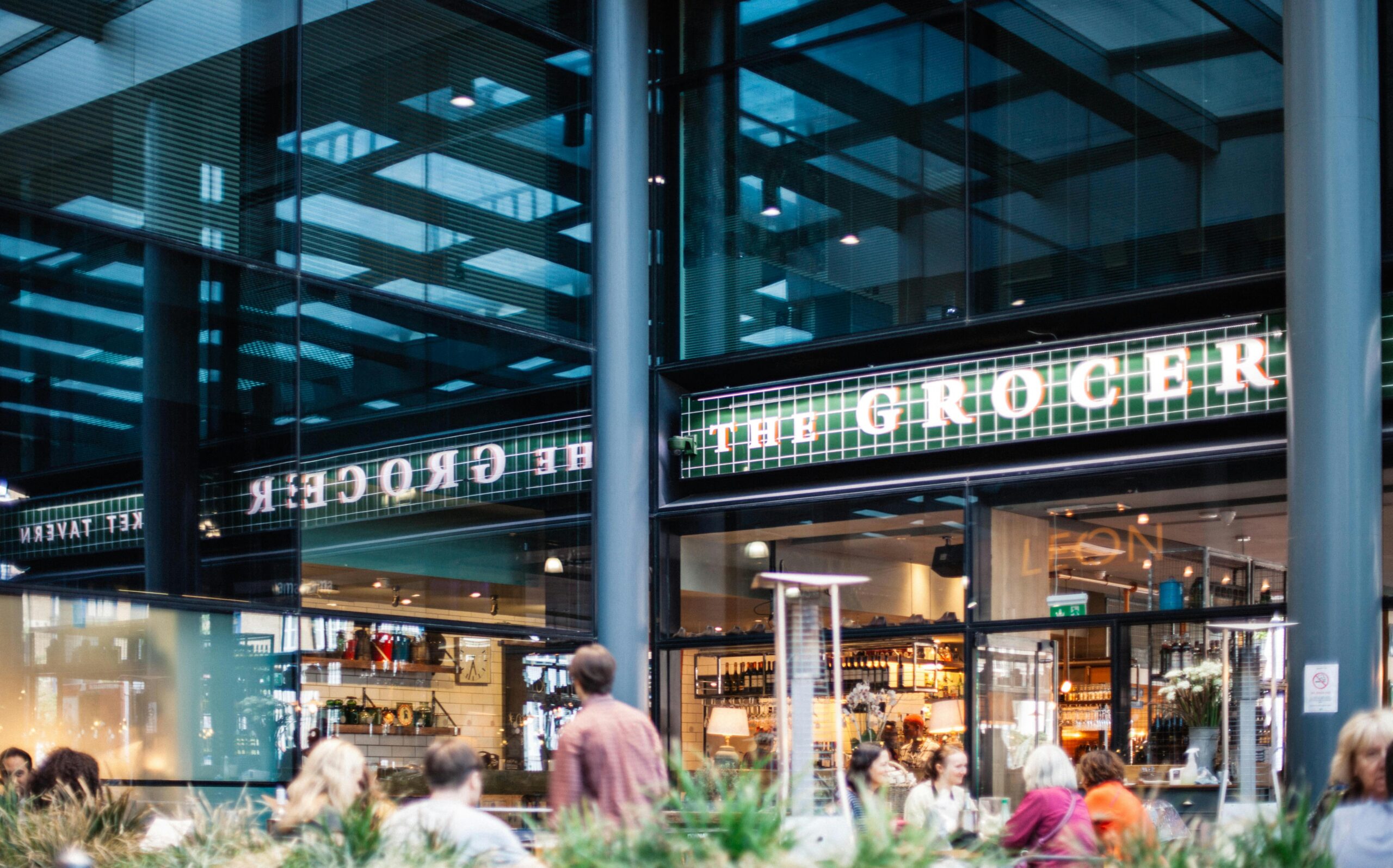 A bustling grocery store with a modern design and visible clientele.