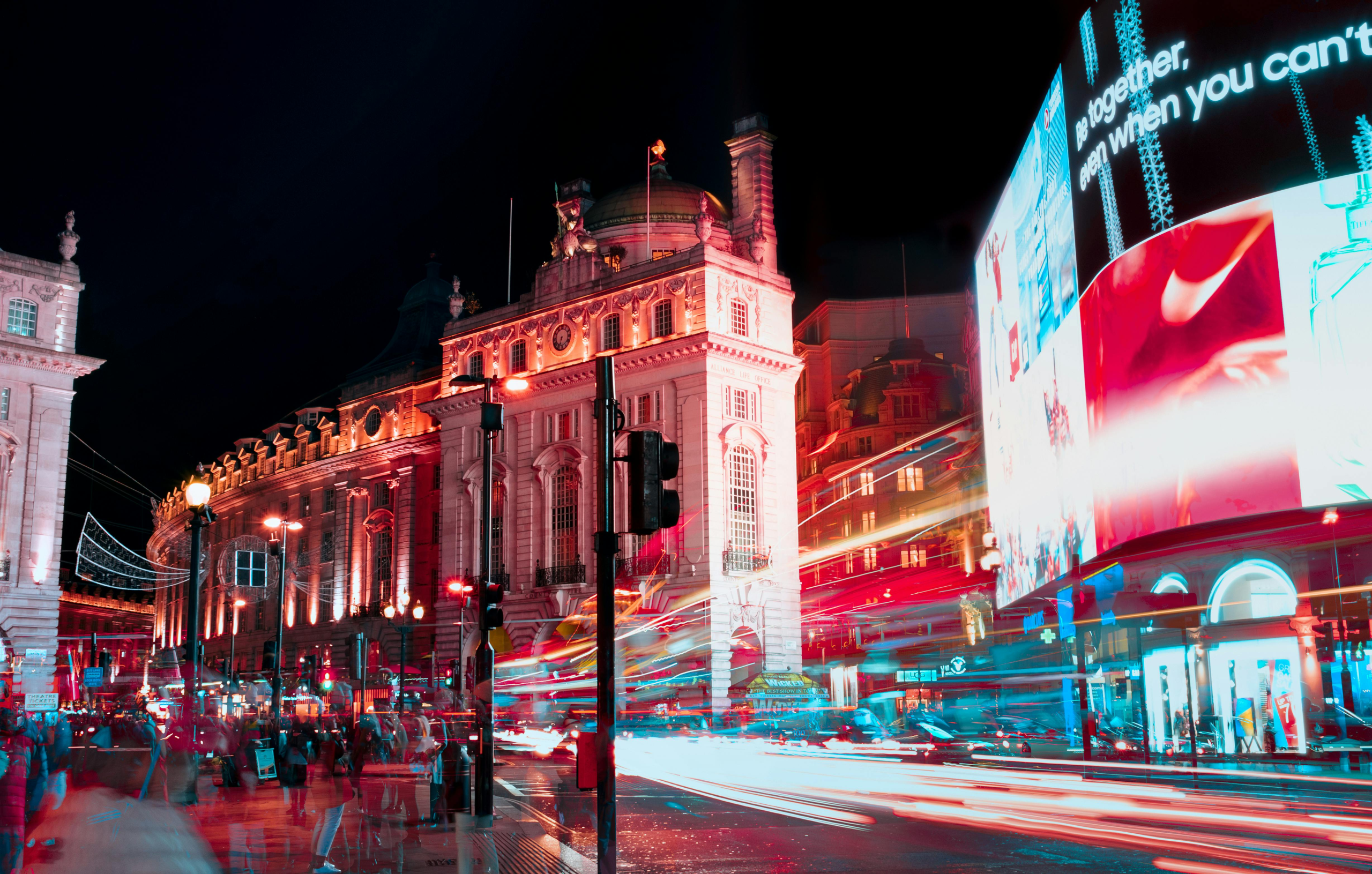Long exposure captures vibrant city lights and nightlife at Piccadilly Circus, London.