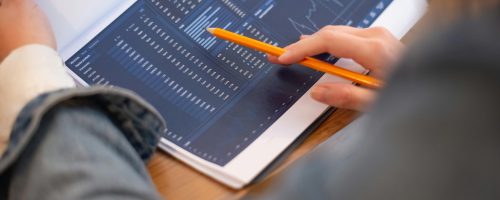 pexels-photo-6829522-6829522 Focused image of hands analyzing business graphs and charts in a folder, highlighting data insights.